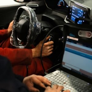 A man sitting in a car using a laptop computer